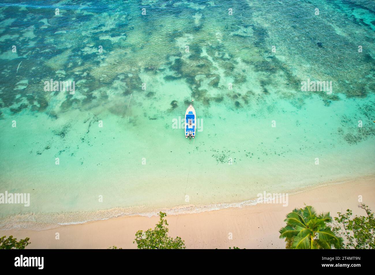 Drone de la plage de baie lazare, bateau pêcheur à quai à marée basse près du rivage, eau turquoise, journée ensoleillée, Mahé Seychelles Banque D'Images