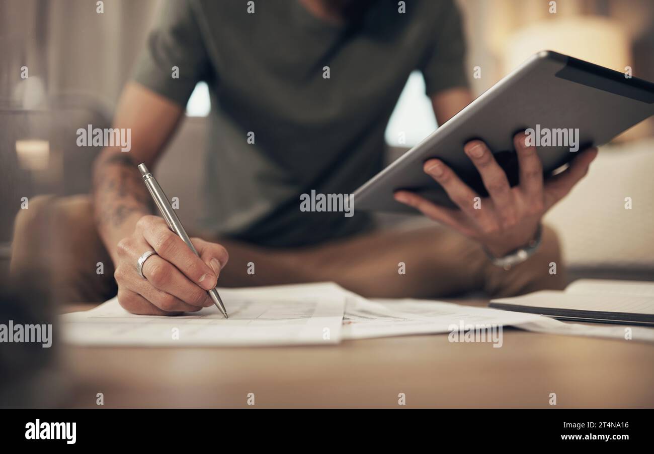 L'outil de budgétisation le plus pratique qui soit. un homme utilisant une tablette numérique tout en parcourant la paperasserie à la maison. Banque D'Images