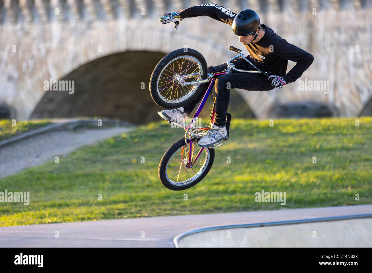 Jeune homme effectuant des acrobaties sur un vélo bmx dans un skatepark, Agen, France Banque D'Images