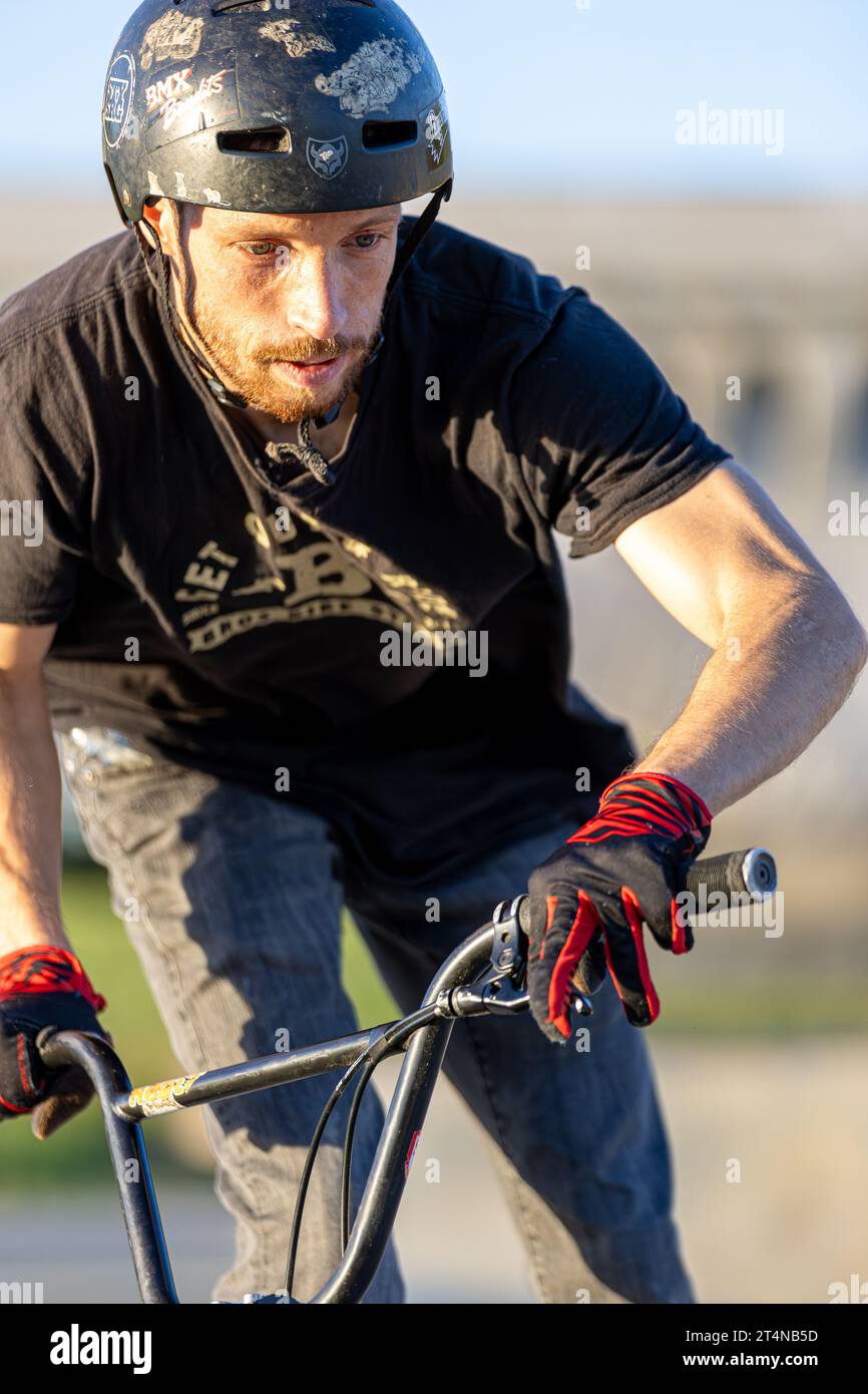 Jeune homme effectuant des acrobaties sur un vélo bmx dans un skatepark, Agen, France Banque D'Images