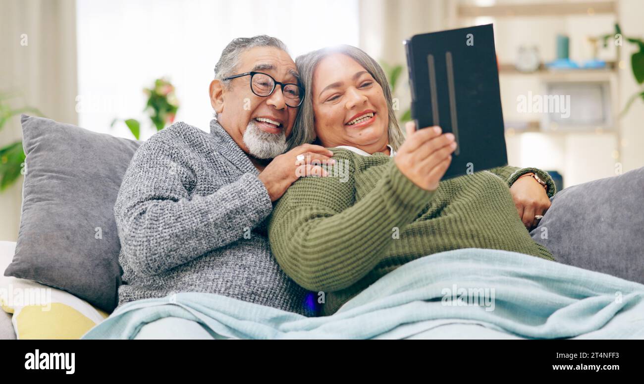 Tablette, relax et couple senior avec retraite, maison et mariage avec humour, bonheur et gai. Appartement, femme âgée et vieil homme avec la technologie Banque D'Images