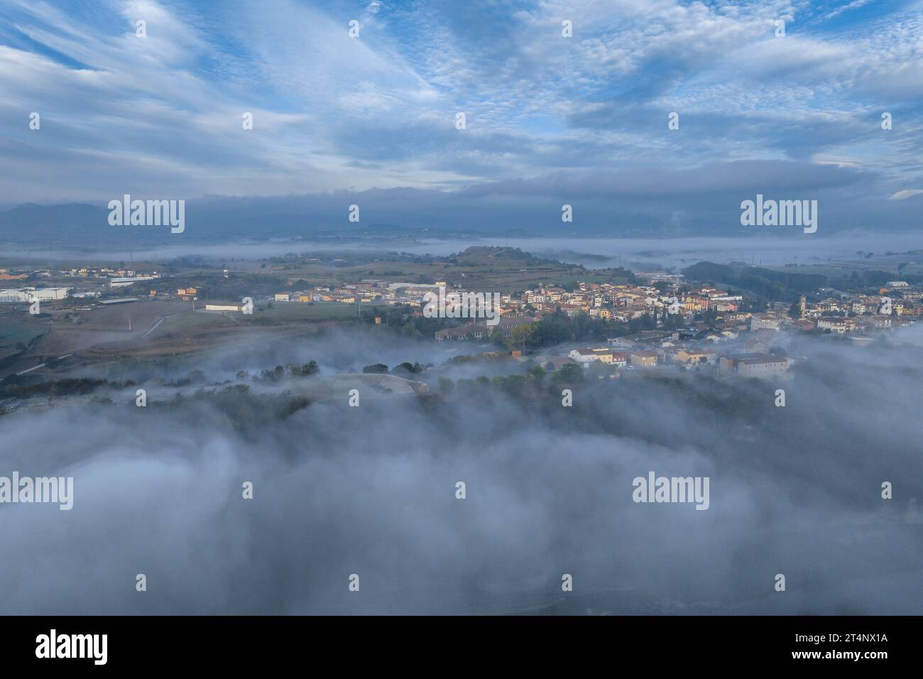 Vue aérienne du village de Roda de Ter entouré de brouillard un matin d'automne dans la Plana de Vic (Osona, Barcelone, Catalogne, Espagne) Banque D'Images