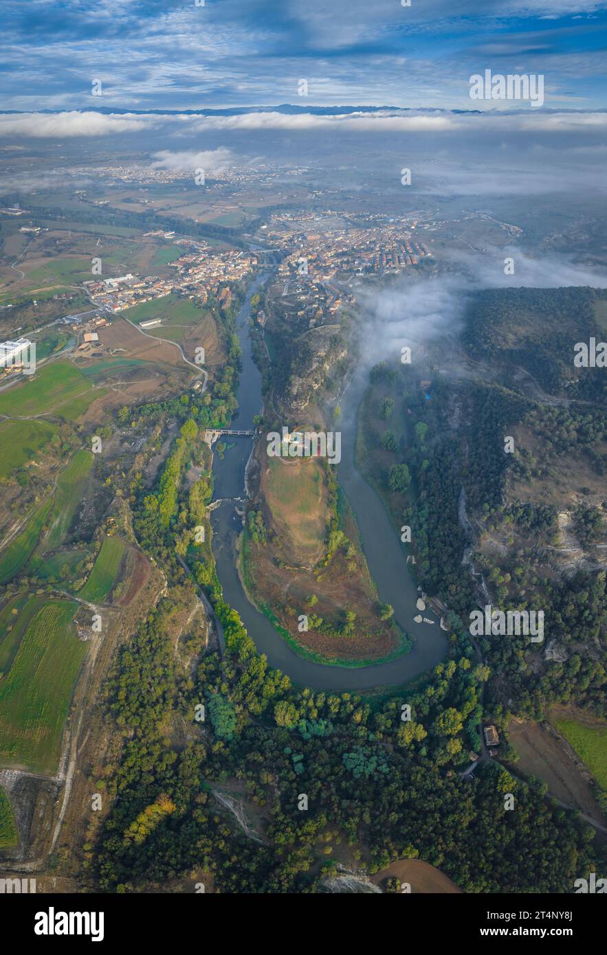 Vue panoramique verticale et aérienne du méandre de la rivière Ter lorsqu'elle traverse Roda de Ter un matin brumeux (Osona, Barcelone, Espagne) Banque D'Images