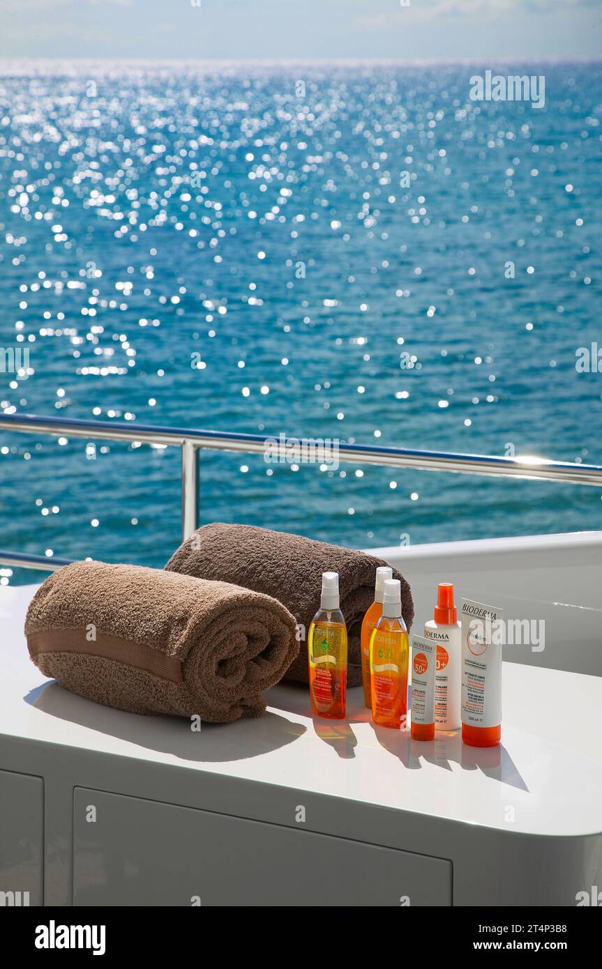 Produits de protection solaire Biotherm et Bioderma sur un yacht de luxe avec les Caraïbes étincelantes en toile de fond. Banque D'Images