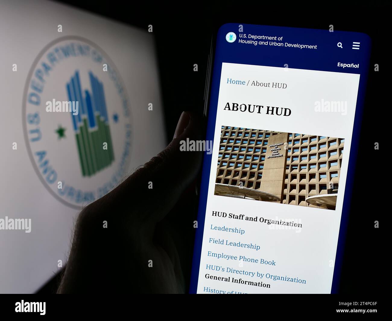 Personne détenant un téléphone portable avec la page Web du ministère américain du logement et du développement urbain (HUD) devant le logo. Concentrez-vous sur le centre de l'écran du téléphone. Banque D'Images