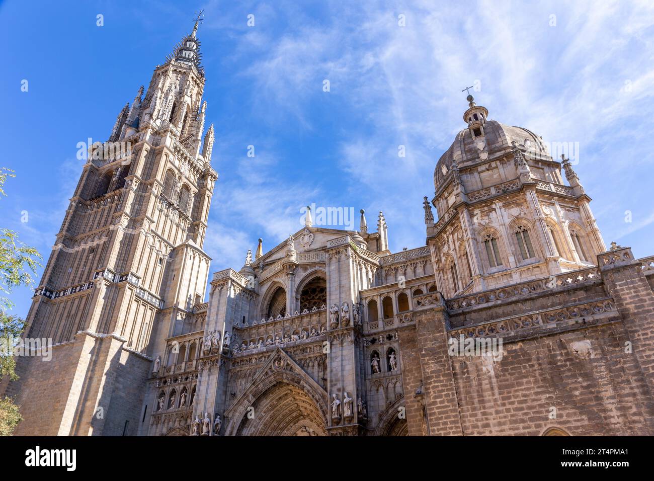 Cathédrale de Tolède, façade gothique de l'église avec portails, statues, reliefs, clocher et dôme de chapelle mozarabe vu de la Plaza del Ayuntamiento, Espagne. Banque D'Images