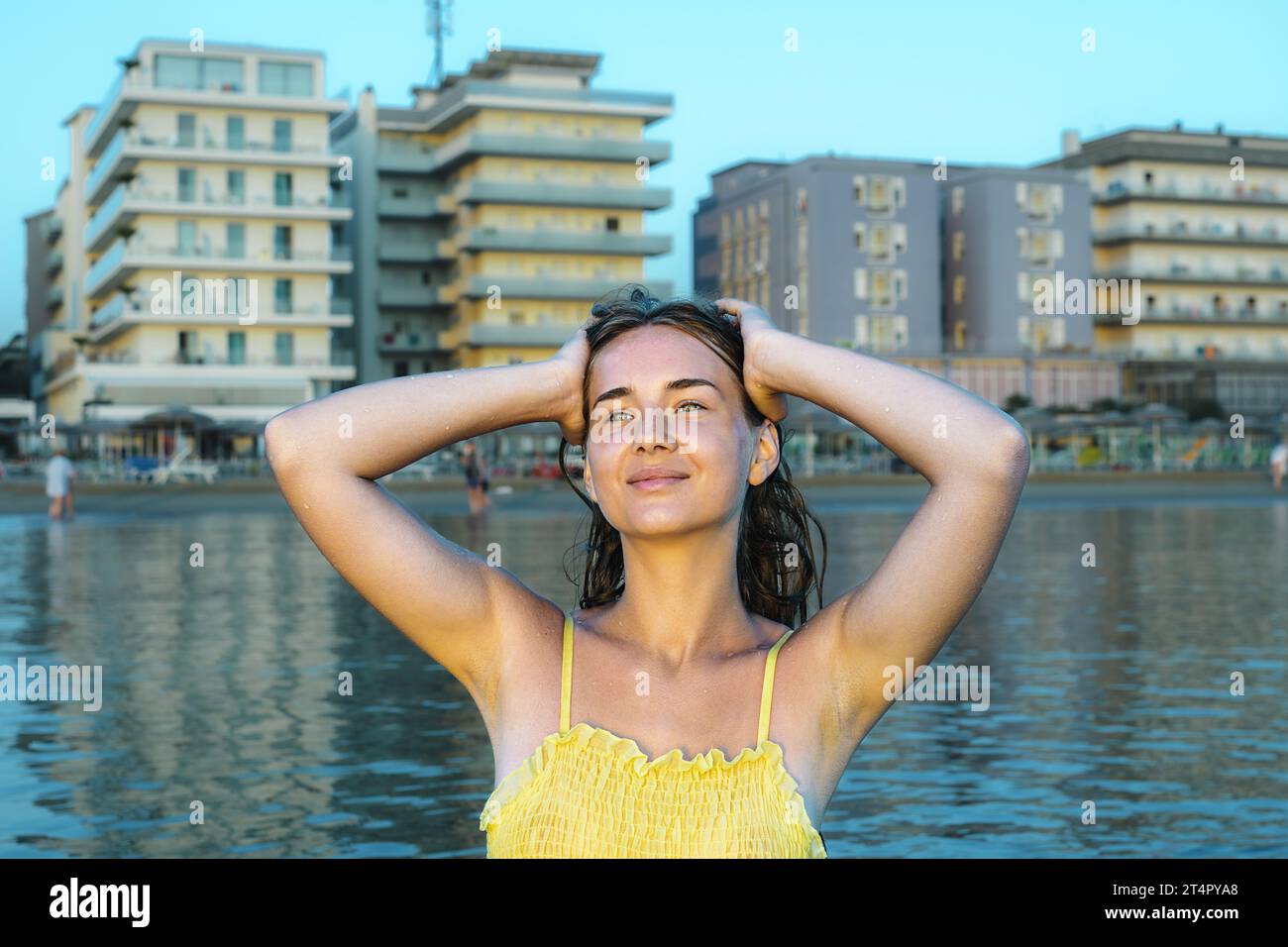 Jeune femme sur la plage dans une robe jaune. Vacances d'été sur la plage. Banque D'Images