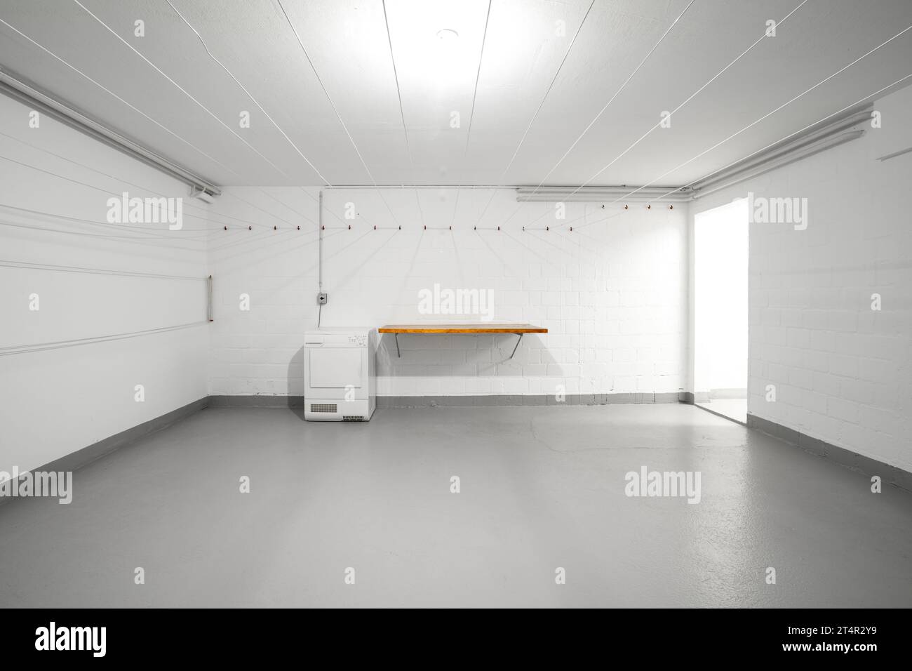 Immeuble d'appartements usage commun buanderie vide. Vide dessus de table en bois, sèche-linge et fils suspendus sur le mur. Vue grand angle, pas de gens. Banque D'Images