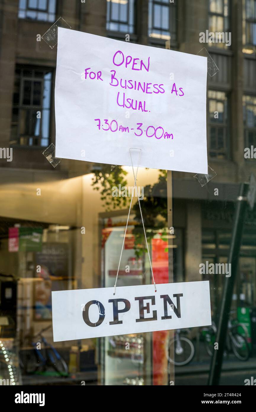 Ouvrir pour les affaires comme d'habitude signe sur une vitrine Banque D'Images