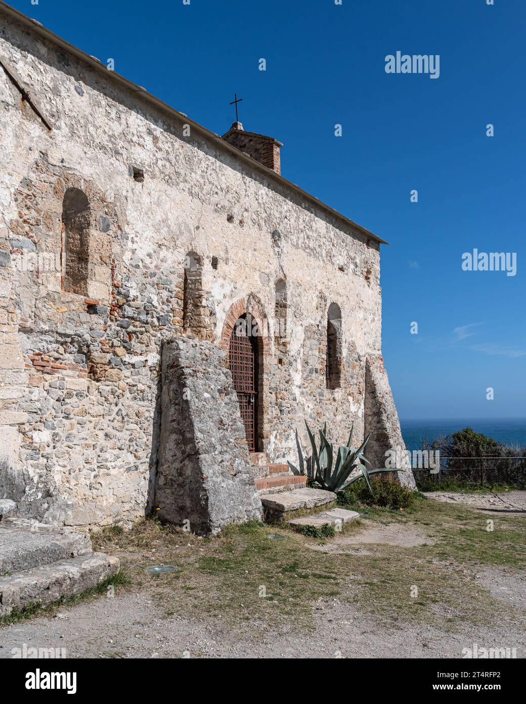 Une vue extérieure d'un bâtiment en briques vieilli avec de multiples ouvertures de fenêtres et de portes Banque D'Images