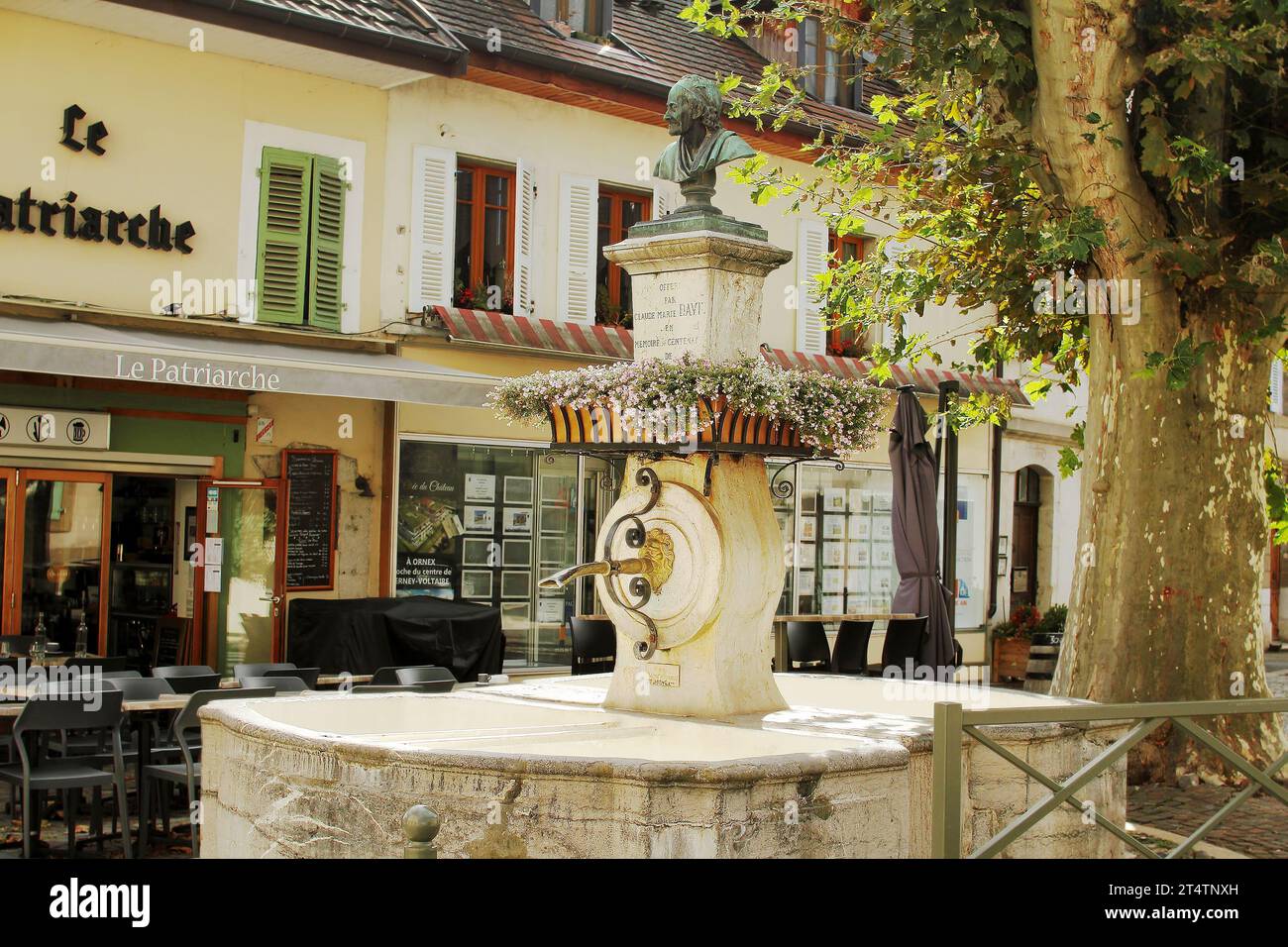Une belle fontaine ancienne avec un buste de Voltaire près du restaurant Patriarche à Ferney-Voltaire, France. Ferney-Voltaire une ville et commune en F Banque D'Images