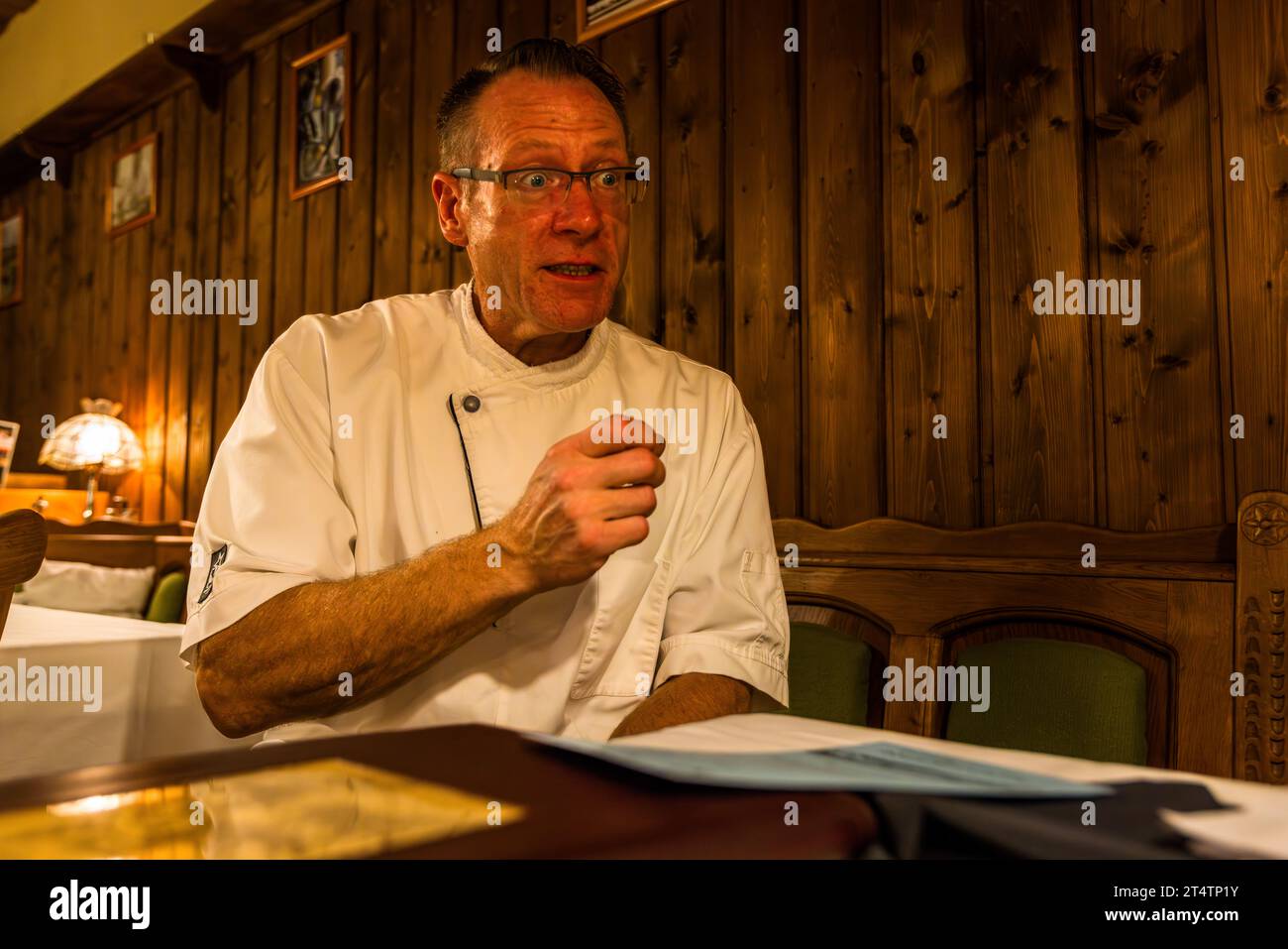 Le chef Johann Lemberger, propriétaire du restaurant Altmugler sonne à Bad Neualbenreuth, explique sa carte de poissons. Altmugl, Allemagne Banque D'Images