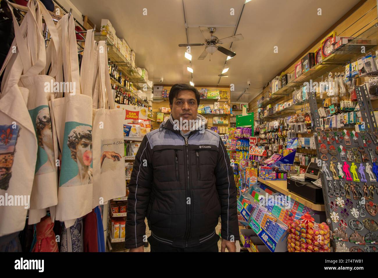 Florence, Italie. Un travailleur migrant bangladais dans une boutique de souvenirs à Florence, la capitale de la région toscane en Italie. Banque D'Images