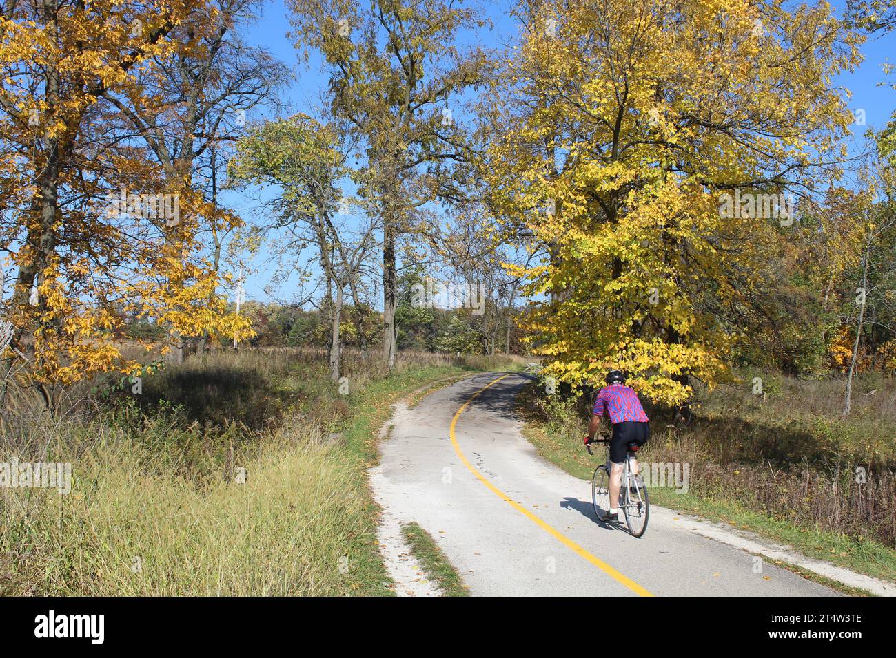 Homme en chemise colorée à vélo sur le North Branch Trail à Miami Woods à Morton Grove, Illinois Banque D'Images