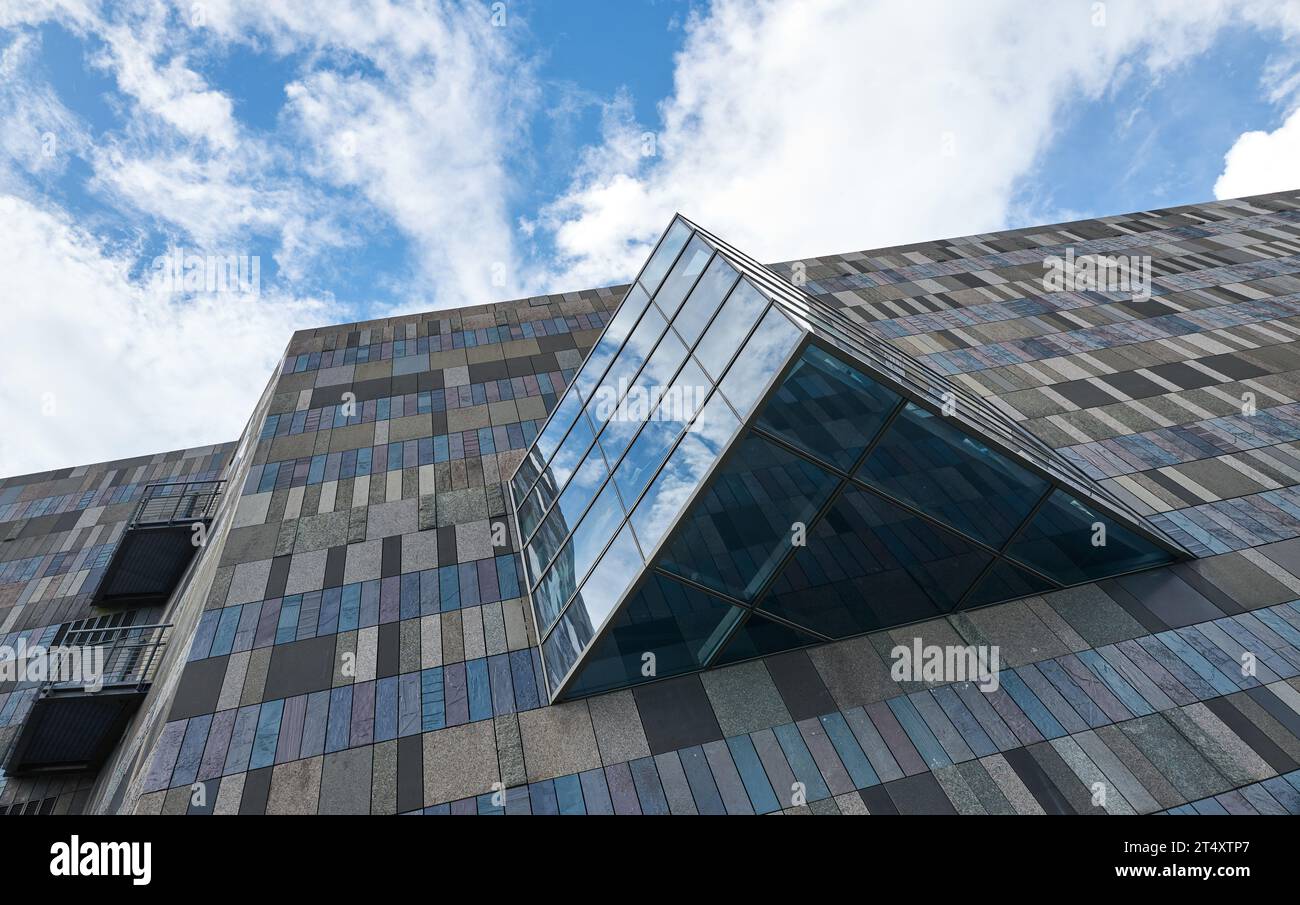 Mur de carreaux de pierre de marbre rectangle et fenêtre en verre triangulaire de l'extérieur du bâtiment moderne Banque D'Images