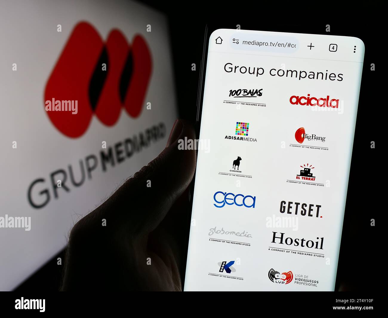 Personne détenant un téléphone mobile avec le site Web de la société multimédia espagnole Mediapro Group devant le logo. Concentrez-vous sur le centre de l'écran du téléphone. Banque D'Images