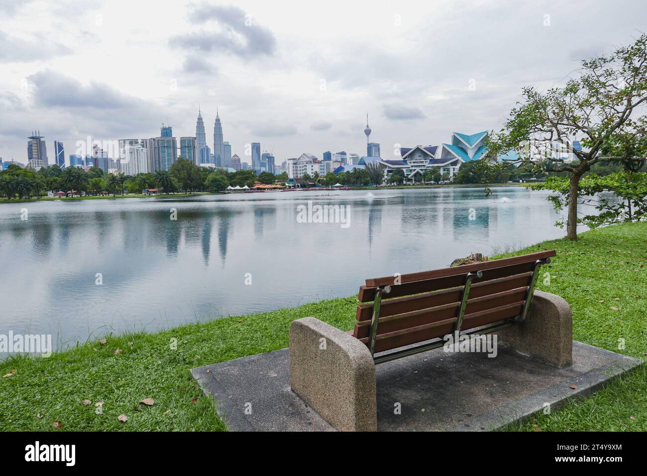 Banc de parc surplombant le lac Titiwangsa et Kuala Lumpur Skyline Banque D'Images