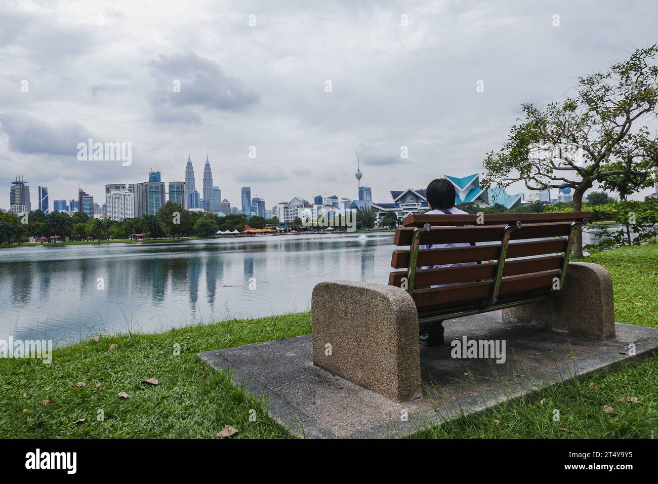 Banc de parc surplombant le lac Titiwangsa et Kuala Lumpur Skyline Banque D'Images