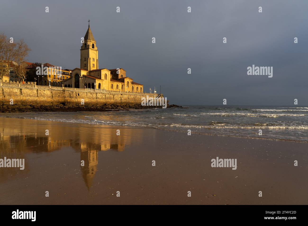 Gijón, ESPAGNE - 16 DÉCEMBRE 2021 : église San Pedro sur la plage de San Lorenzo illuminée par le soleil au lever du soleil dans la ville de Gijon, Asturies, Espagne Banque D'Images