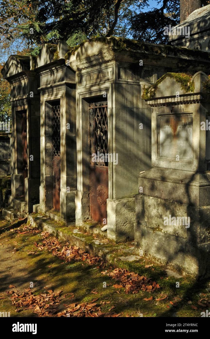 Une rangée de mausolées ensoleillés dans le cimetière historique du Père Lachaise de Paris. Banque D'Images