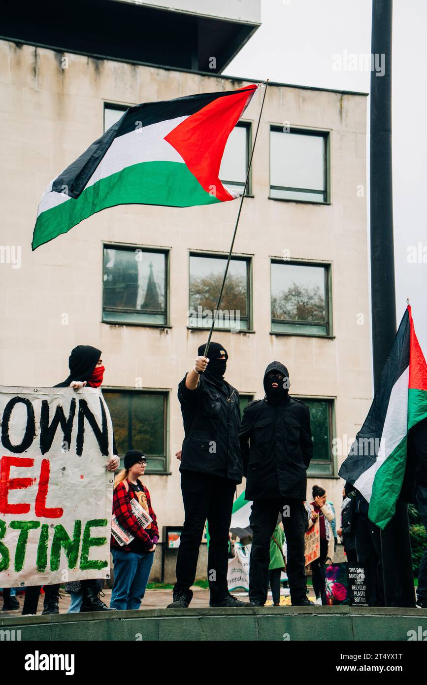 Des manifestants dans les balaclavas agitent des drapeaux palestiniens devant le centre civique lors d'une marche de protestation. Newcastle Civic Centre le 28 octobre 2023 Banque D'Images