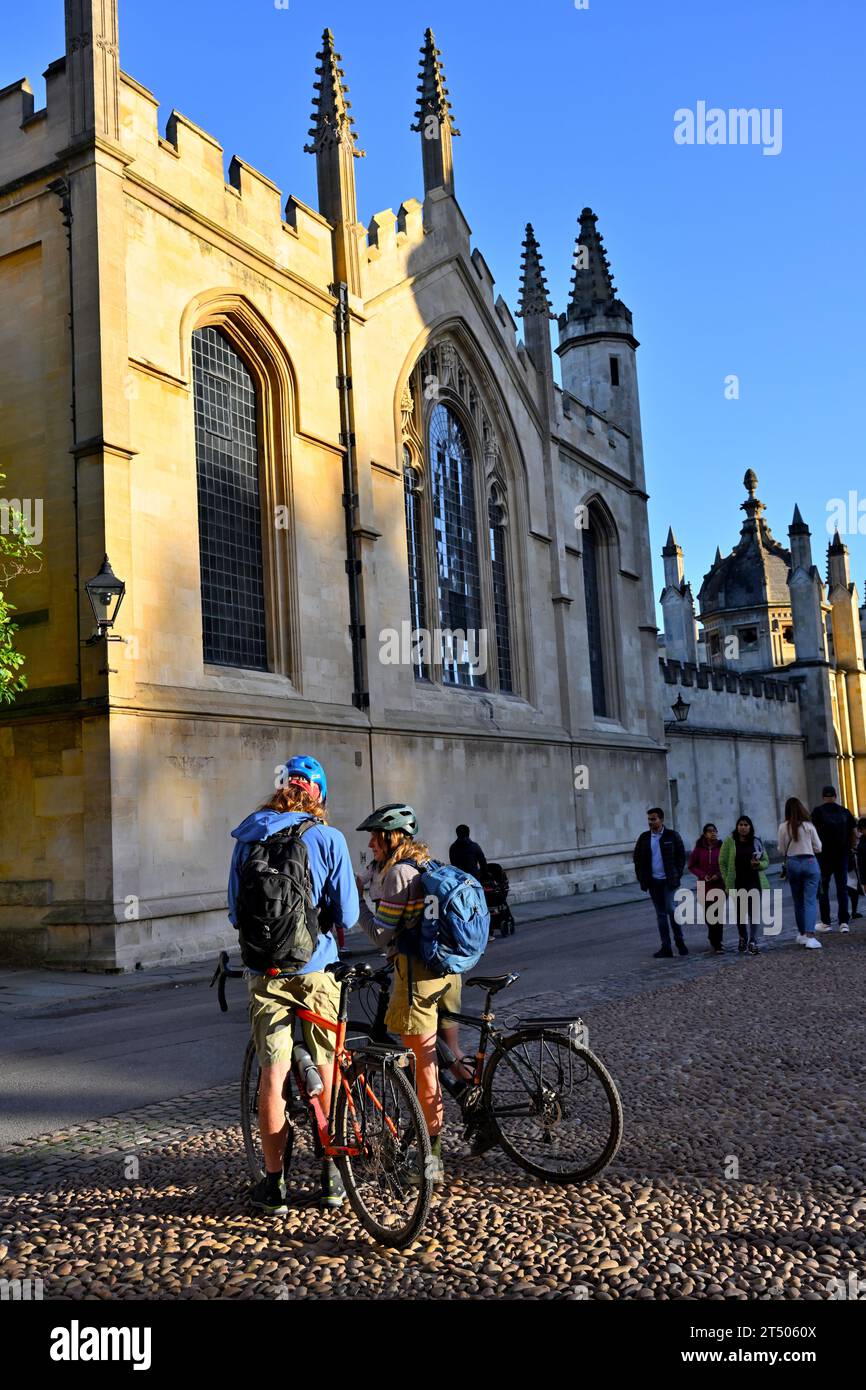 Deux cyclistes avec des sacs à dos vérifiant l'emplacement en fin d'après-midi par All Souls College Chapel, Oxford Banque D'Images