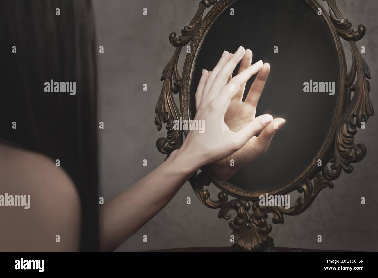femme touche le reflet de sa main sur un miroir, concept abstrait Banque D'Images