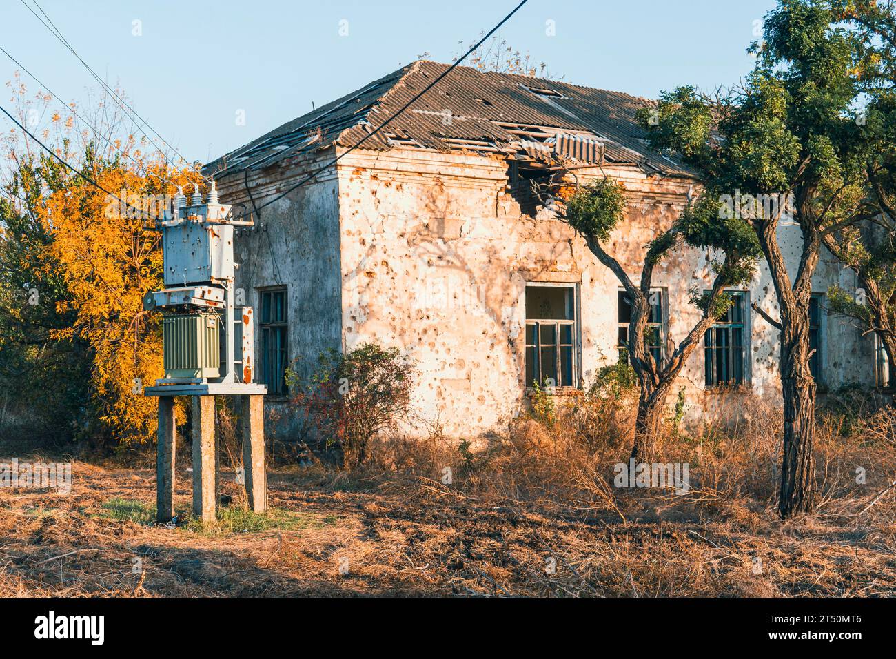 Un transformateur électrique près d'une maison endommagée par des obus. Guerre en Ukraine. Invasion russe de l'Ukraine. Destruction des infrastructures Banque D'Images