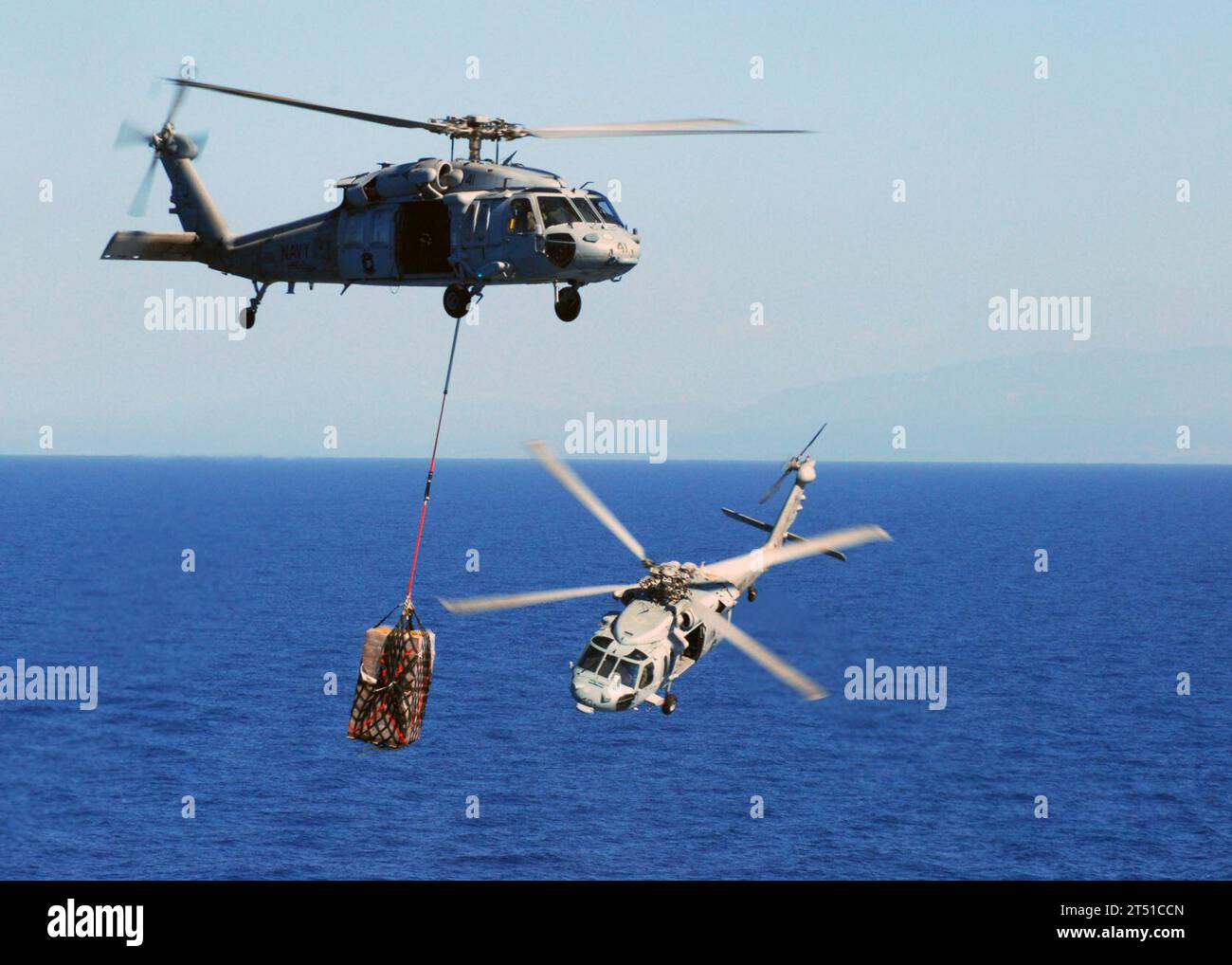 1001273165S-071 BAIE DE GRAND GOAVE, Haïti (27 janvier 2010) un hélicoptère MH-60S Sea Hawk de l'Escadron de combat en mer (HSC) 22 transfère des palettes de repas prêts à manger du navire de cargaison sèche et de munitions USNS Sacagawea (T-AKE-2) au navire d'assaut amphibie polyvalent USS Bataan (LHD 5) aider à l'effort de secours en Haïti. Bataan, les navires amphibies de débarquement à quai USS fort McHenry (LSD 43), USS Gunston Hall (LSD 44) et USS carter Hall (LSD 50) participent à l'opération Unified Response et fournissent des capacités de soutien militaire à l'UA civile Banque D'Images