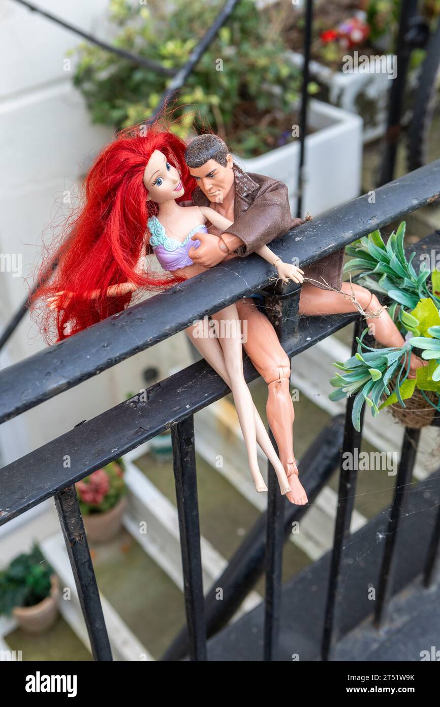 Deux poupées embrassant sur une clôture métallique Banque D'Images