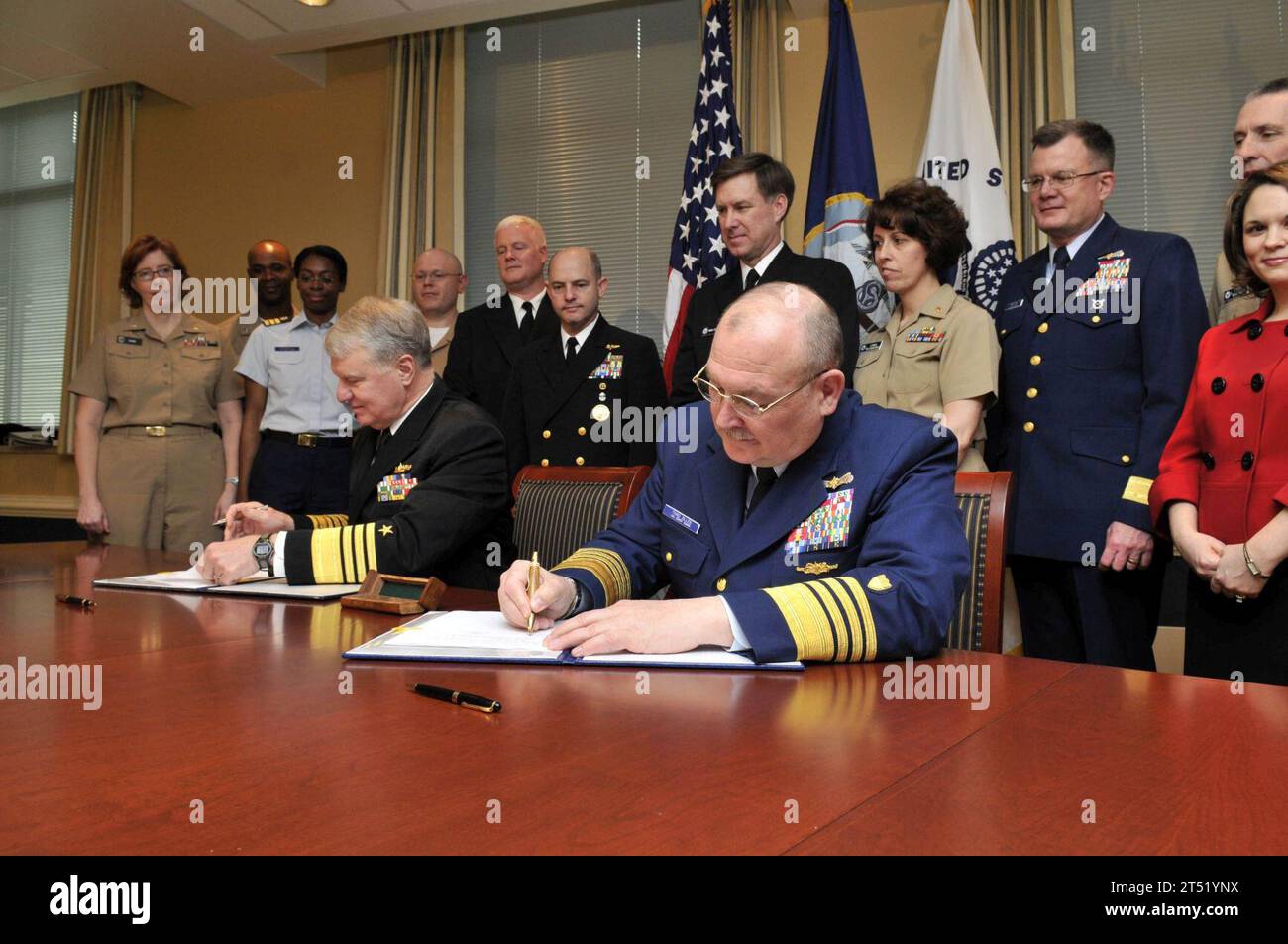 0904018273J-014 WASHINGTON (1 avril 2009) le chef des opérations navales (CNO), l'amiral Gary Roughead, à gauche, et le commandant de la Garde côtière l'amiral Thad W. Allen signent un protocole d'entente pour le programme Safe Harbor lors d'une cérémonie de signature au Pentagone. L’entente reflète l’engagement de la Marine et de la Garde côtière à fournir toute une vie de soins non médicaux personnalisés, coordonnés et coordonnés aux militaires gravement blessés, malades ou blessés et à leurs familles. Marine Banque D'Images
