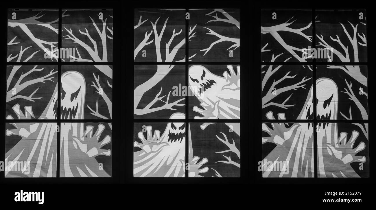 Les autocollants de fenêtre Halloween Ghosts s'allument la nuit Banque D'Images