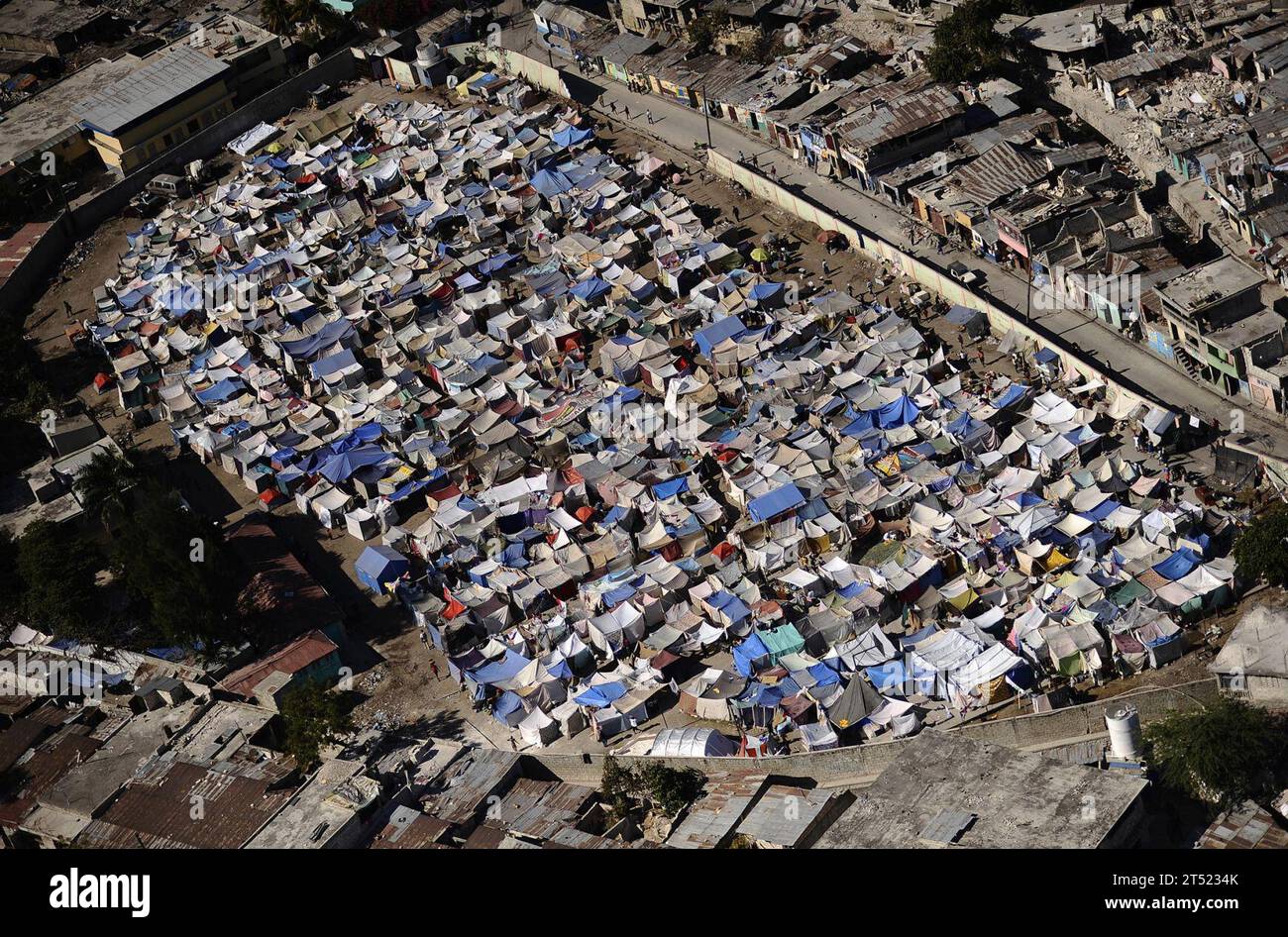 1001285345W-266 PORT-au-PRINCE, Haïti (28 janvier 2010) des milliers d'Haïtiens déplacés vivent dans l'une des nombreuses villes de tentes situées dans la capitale Port-au-Prince à la suite du tremblement de terre dévastateur de magnitude 7,0 qui a frappé la région le 12 janvier 2010. Le navire d'assaut amphibie polyvalent USS Bataan (LHD 5) et les navires amphibies de débarquement à quai USS fort McHenry (LSD 43), USS Gunston Hall (LSD 44) et USS carter Hall (LSD 50) participent à l'opération Unified Response en tant que Mission amphibie de secours de Bataan en fournissant des capacités de soutien militaire aux autorités civiles Banque D'Images