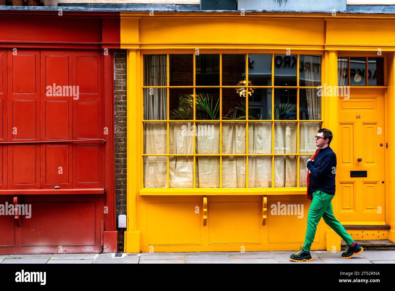 Un jeune homme passe devant une propriété colorée dans Bermondsey Street, Bermondsey, Londres, Royaume-Uni Banque D'Images