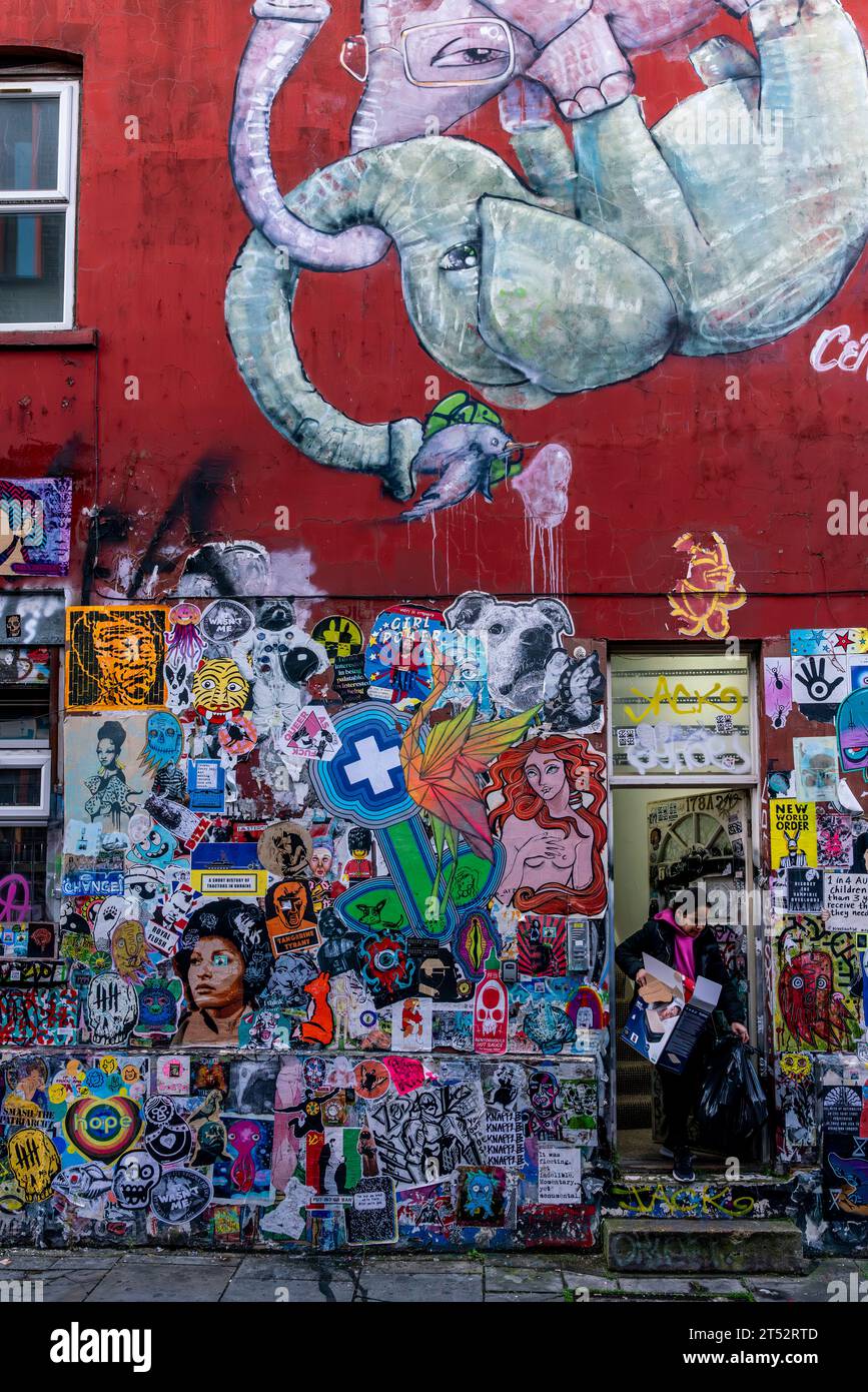 Une jeune femme sortant les ordures dans Une propriété colorée de Brick Lane, Londres, Royaume-Uni Banque D'Images