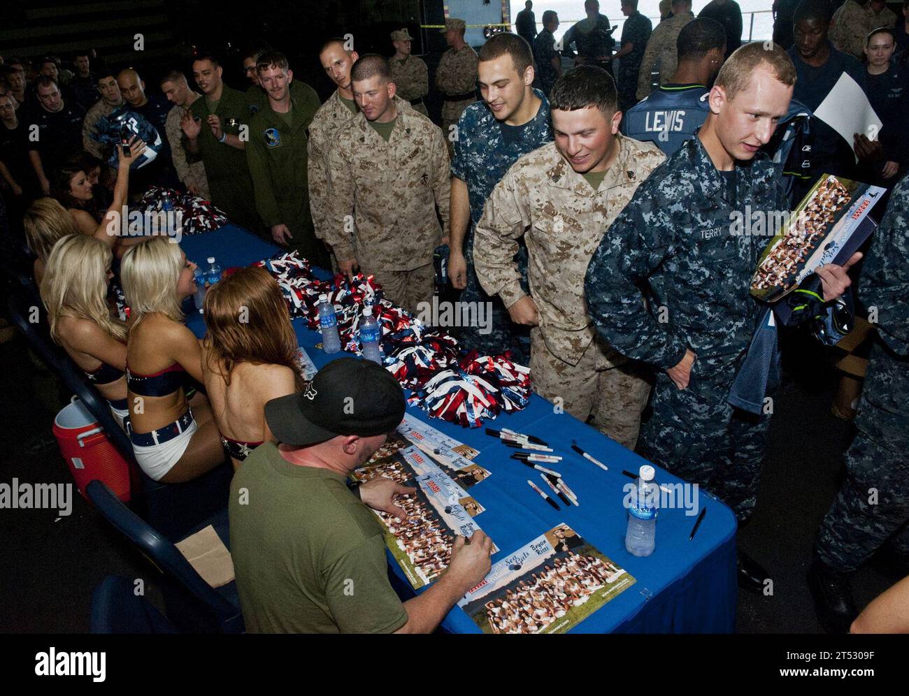 120213DX615-606 ARABIAN SEA (13 février 2012) Seattle Seahawks Cheerleaders, les Sea GALs et le comédien Brian Ricci saluent les marins et les Marines à bord du navire d'assaut amphibie USS Makin Island (LHD 8) et signent des autographes. Les Sea GALs et Ricci, ainsi que le défensif du Seahawk Roy Lewis, ont visité le navire dans le cadre d'une tournée sponsorisée par Armed Forces Entertainment pour aider à améliorer le moral des troupes déployées. L'île Makin et les Marines embarqués affectés à la 11e unité expéditionnaire des Marines (11e MEU) sont déployés pour soutenir les opérations de sécurité maritime et les efforts de coopération en matière de sécurité sur le théâtre d'opérations dans l'U Banque D'Images