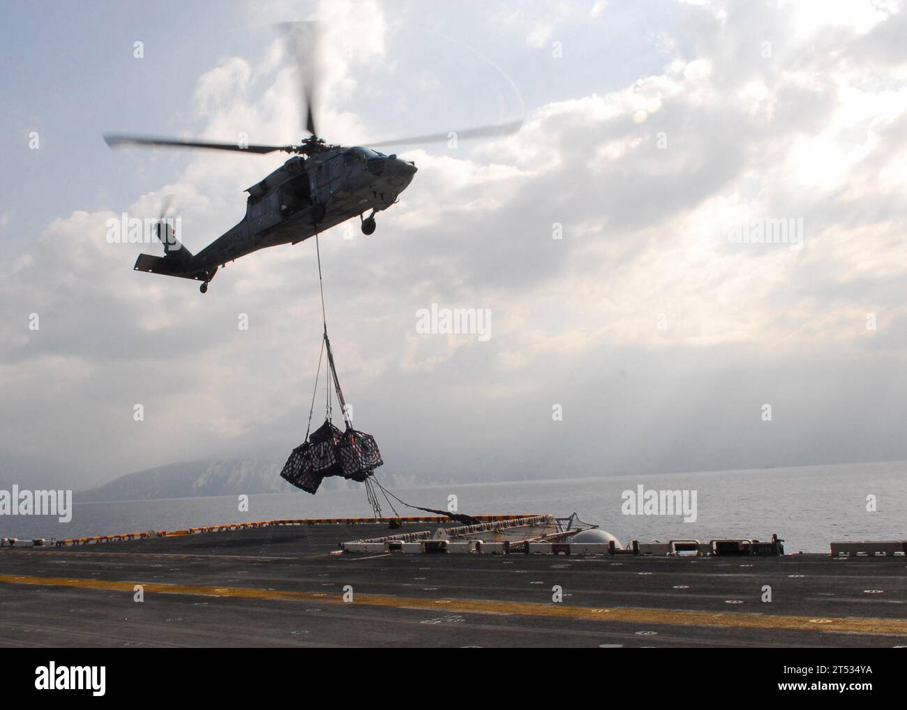 1002141092P-028 BAIE DE GRAND GOAVE, Haïti (14 février 2010) un hélicoptère MH-60S Sea Hawk de l'Escadron de combat en mer (HSC) 22 livre des palettes de fournitures au navire d'assaut amphibie polyvalent USS Bataan (LHD 5) lors d'un réapprovisionnement vertical. Bataan mène des opérations humanitaires et de secours en cas de catastrophe dans le cadre de l’opération Unified Response après qu’un tremblement de terre de magnitude 7,0 ait causé de graves dommages à Port-au-Prince, en Haïti, le 12 janvier. Banque D'Images