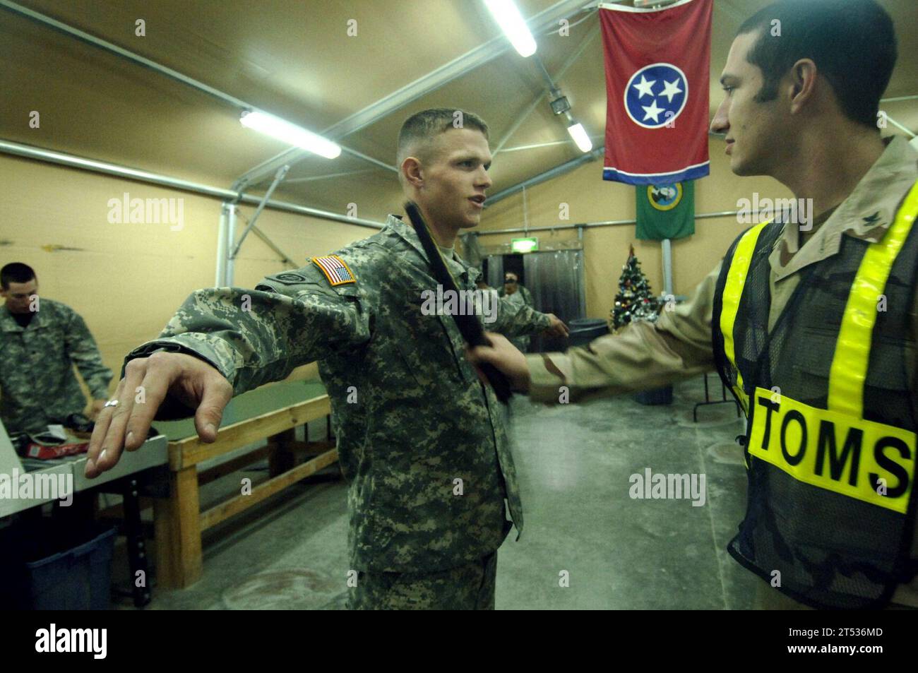 0612128148a-129 Koweït (12 déc. 2006) - Un agent de dédouanement de la Marine inspecte un soldat affecté à la 82e division aéroportée de ArmyХs à la recherche d'éventuels objets non autorisés qui pourraient être dissimulés dans son uniforme. Les bataillons des douanes de la marine sont chargés d ' inspecter les articles tels que les bagages personnels ordinaires, les véhicules et le matériel militaire qui retournent aux États-Unis. Cela garantit que les ravageurs, les plantes étrangères ou les articles de contrebande n'entrent pas aux États-Unis. US Navy Banque D'Images