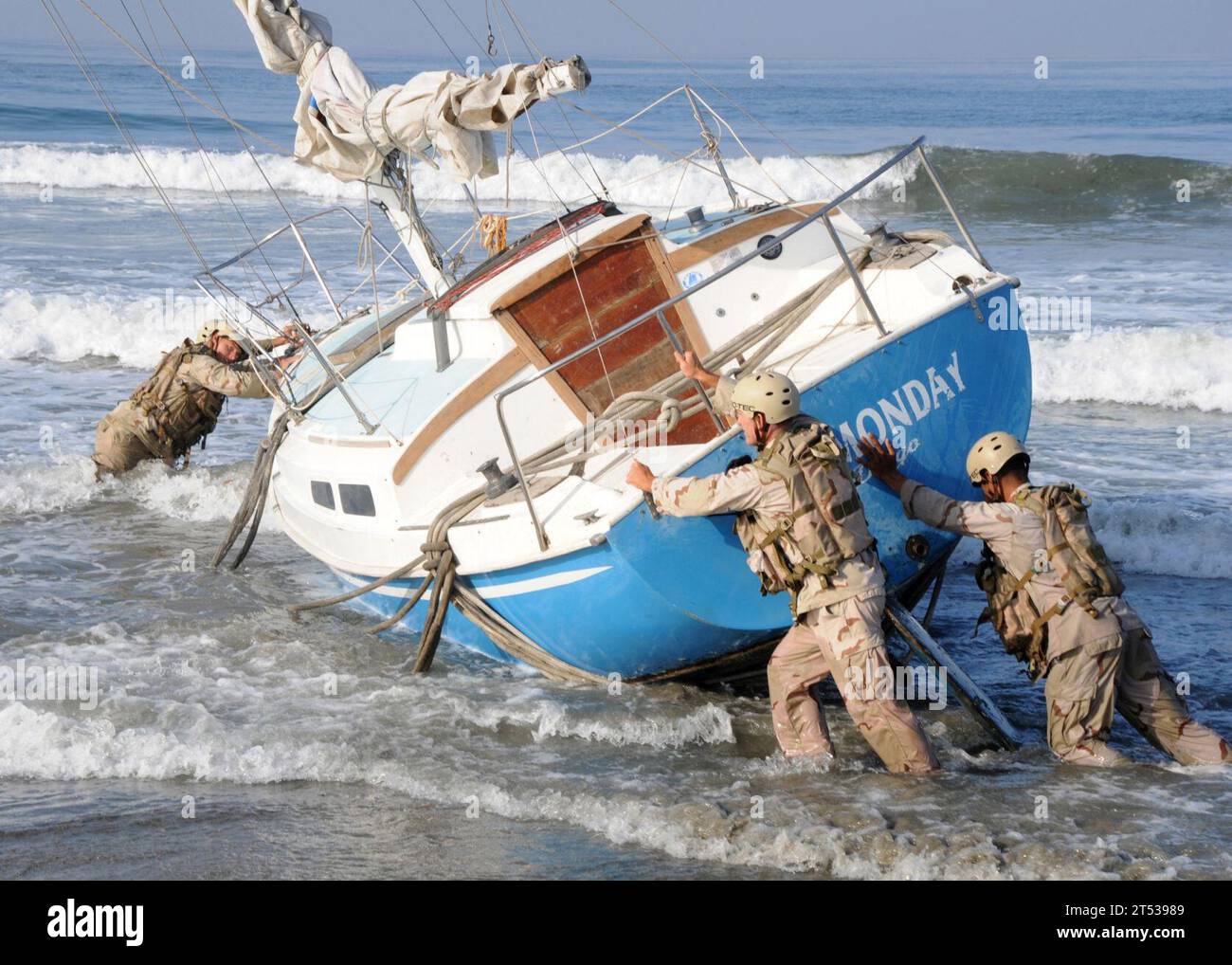 0909171424C-384 CORONADO, Californie (17 septembre 2009) les marins affectés à l'unité de maître de plage (BMU) 1 déplacent un voilier échouée en position pour être récupéré au large de la plage militaire. Le sauvetage du voilier, un effort conjoint du Bataillon de construction amphibie (ACB) 1 et du BMU-1, a empêché les vagues battantes de détruire le voilier et de créer des débris le long des plages protégées par l'armée et la faune. Banque D'Images