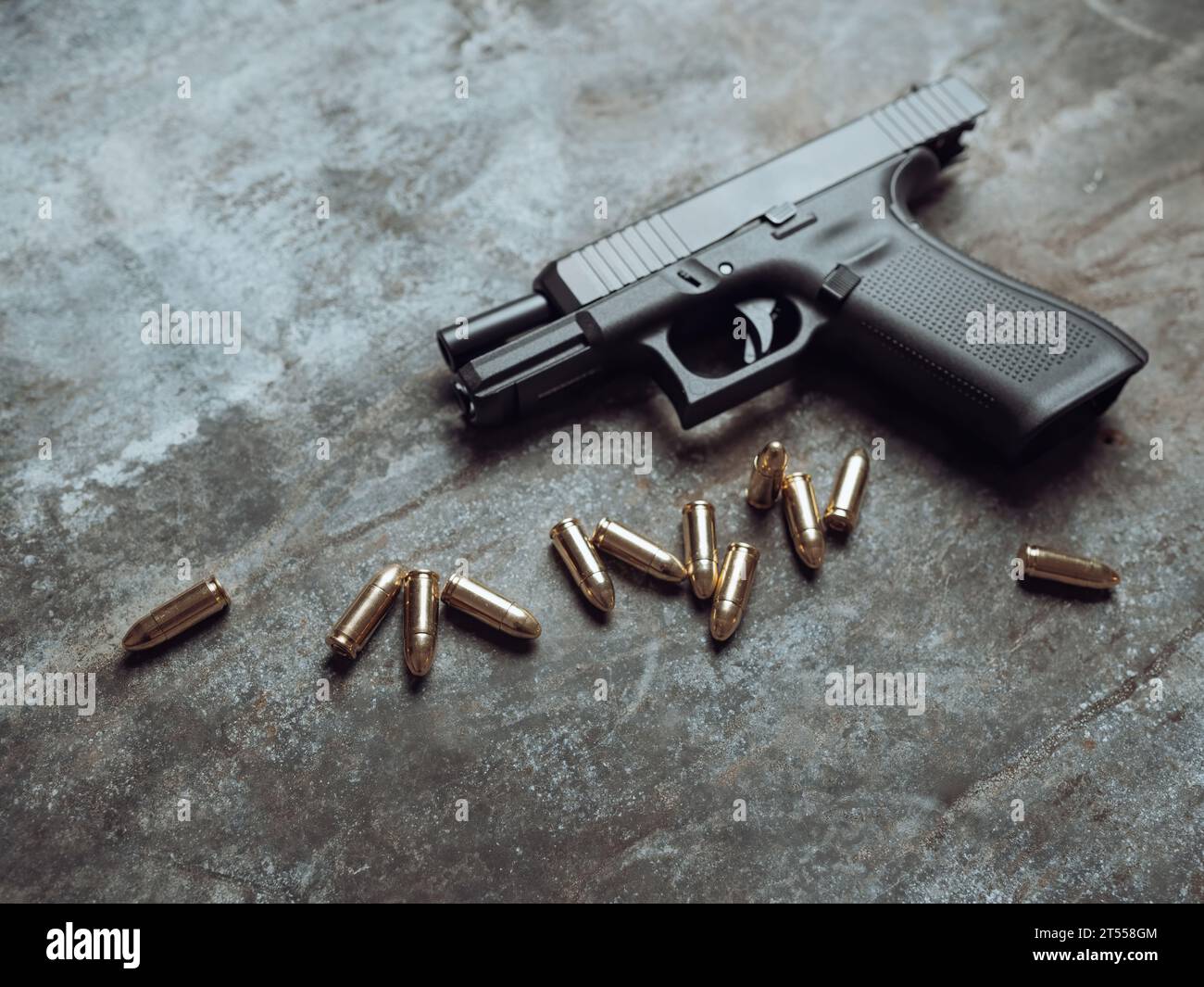 Pistolet à main avec munitions sur fond sombre. arme militaire pistolet 9 mm et tas de balles munitions à la table métallique. Banque D'Images