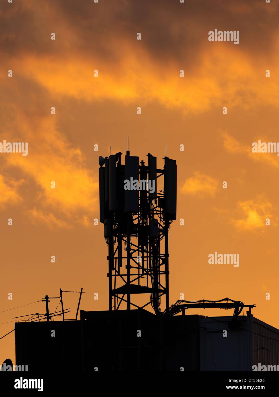 Silhouette de tour de télécommunication avec antennes de panneau de micro-ondes, unités d'émetteur à distance, technologie sans fil, GSM, 5G, fibres optiques sur le toit de b Banque D'Images