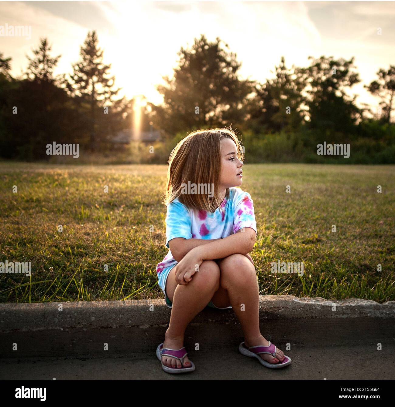 Belle jeune fille assise à l'extérieur en été Banque D'Images