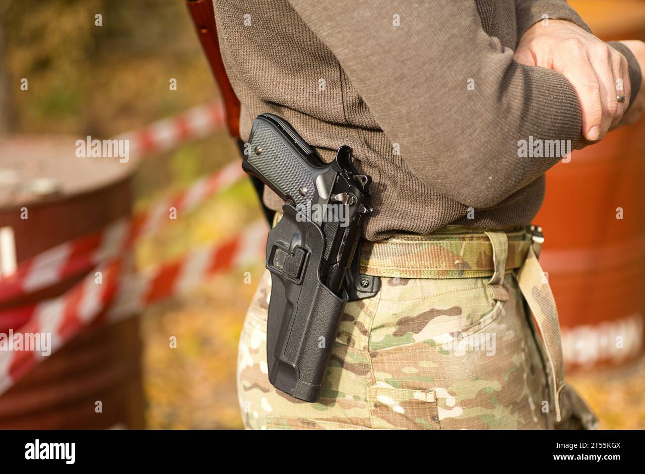 pistolet noir dans un étui sur la ceinture d'un homme en uniforme, couleurs multicum Banque D'Images