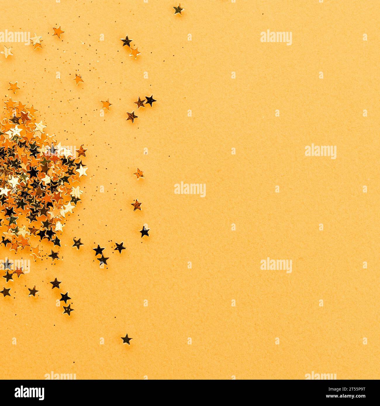 Fond festif doré avec des étoiles dorées et des confettis scintillants. Espace de pose et de copie plat pour le texte. Concept de vacances tendance. Banque D'Images Fond festif doré avec des étoiles dorées et des confettis scintillants. Espace de pose et de copie plat pour le texte. Concept de vacances tendance. Banque D'Images