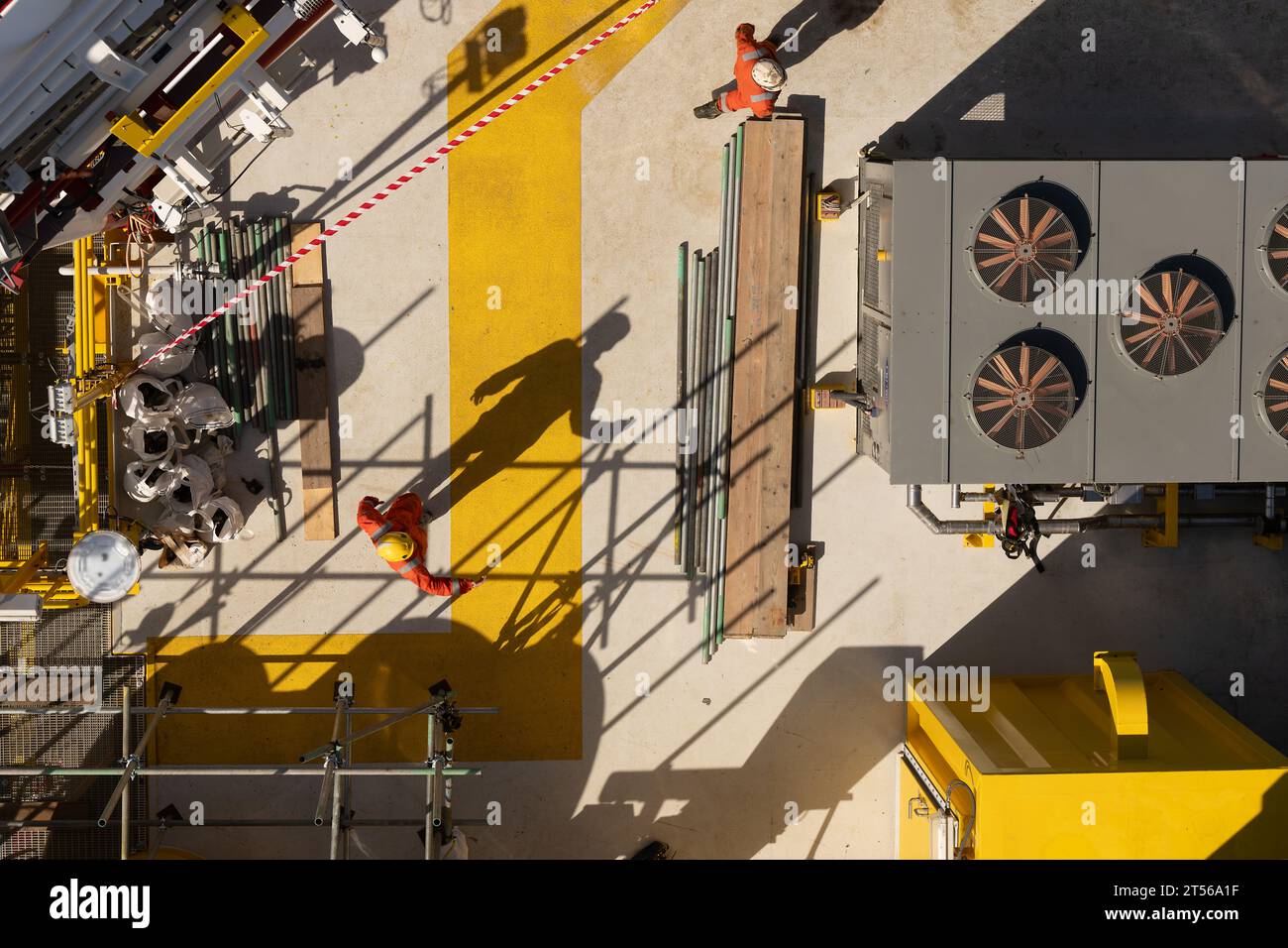 Vue aérienne du pont de la sous-station éolienne offshore avec le travailleur dans l'EPI, l'ombre de sécurité, l'échafaudage et les ventilateurs de refroidissement, mer du Nord, ROYAUME-UNI. Banque D'Images