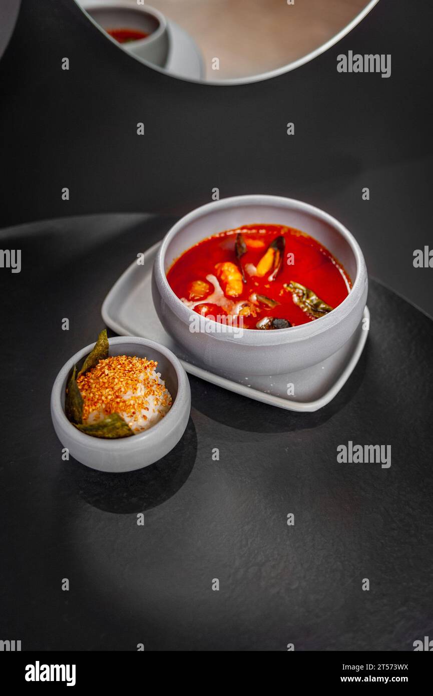 Tom Yum Kung soupe thaïlandaise épicée avec des crevettes dans un bol gris sur un fond de pierre sombre, vue de dessus, espace copie. Photo de haute qualité Banque D'Images