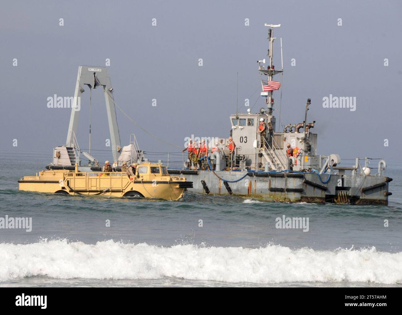 Les Seabees de l'US Navy affectés au Bataillon de construction amphibie (ACB) 1 à bord du Warping Tug 03 se tiennent à disposition pour donner une ligne de remorquage aux marins affectés à l'unité de maître de plage (BMU) 1 à bord de l'amphibie resupp.jpg plus léger Banque D'Images