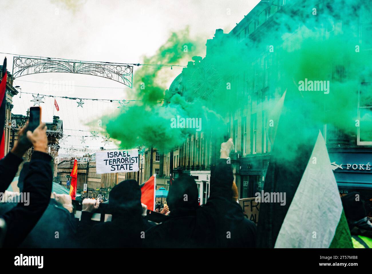 Les manifestants agitent des bombes fumigènes vertes dans les airs et un panneau indique « État terroriste israélien ». Newcastle upon Tyne, Royaume-Uni - octobre 28 2023. Banque D'Images