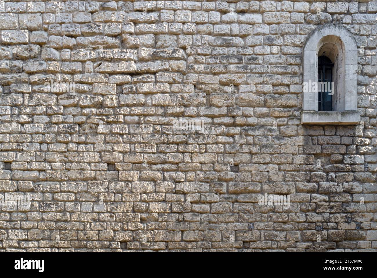 Vieux fond de mur en pierre avec fenêtre voûtée. Le fond texturé sera espacé pour le texte. Banque D'Images