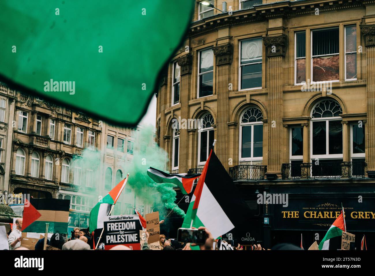 Les manifestants agitent des bombes fumigènes vertes dans les airs tandis que les drapeaux palestiniens agitent devant l'architecture de Newcastle. Newcastle upon Tyne, Royaume-Uni - octobre 28 2023. Banque D'Images